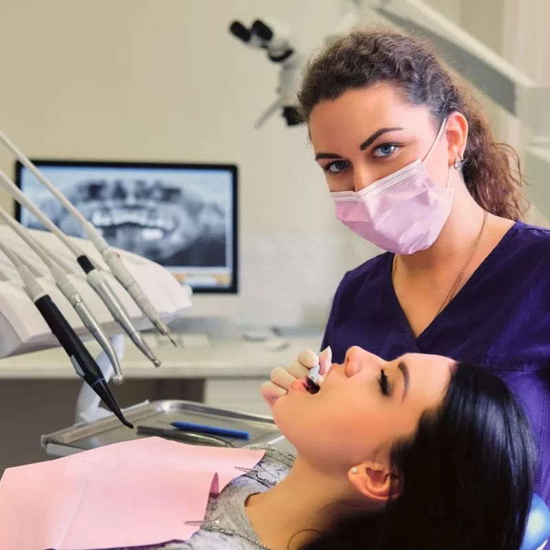 Close-up image of a dentist examining female's teeth in dentistry.